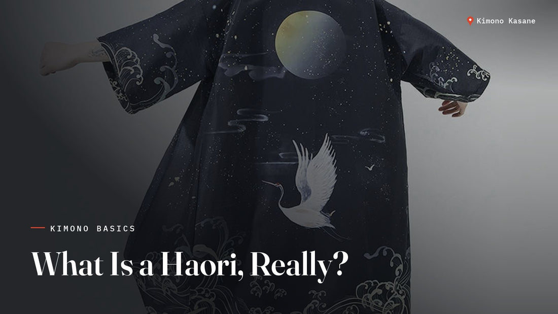 Homme portant un haori bleu nuit orné d'une lune, d'une grue et de vagues japonaises, vu de dos